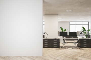 Front view on blank light wall in spacious stylish office with modern computers and plants on dark workspace tables on wooden floor. 3D rendering, mock up