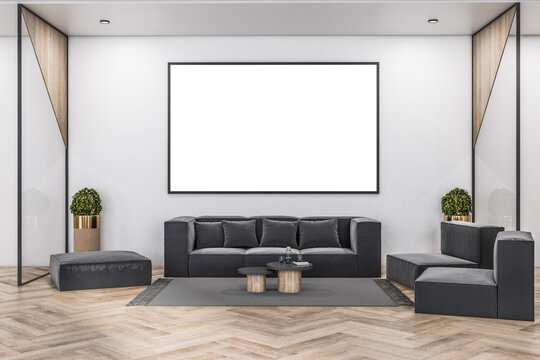Big blank white poster in black picture frame above grey velvet sofa in stylish waiting area with wooden floor. 3D rendering, mock up