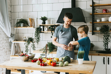 family dad young man and son teenage boy cook vegetable salad in kitchen and spend quality time...