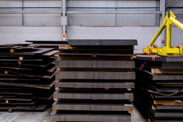 sheets of metal in the warehouse, stacked on top of each other. Stack of steel sheets in warehouse.
