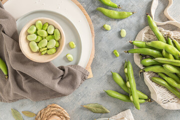 Fresh and raw green broad beans on kitchen table.