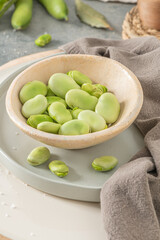 Fresh and raw green broad beans on kitchen table.