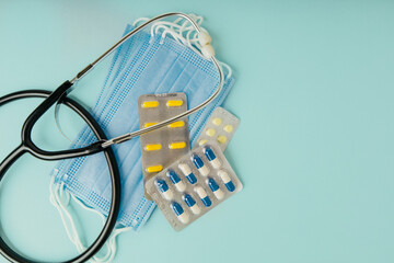 Medical drugs, stethoscope and masks on a blue background. Medicine concept