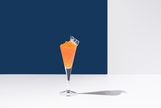 Orange tobiko caviar placed on cocktail glass with ice