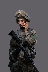 Naklejka premium Shot of militant woman dressed in protective suit talking on smartphone against grey background.