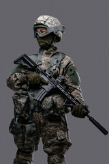 Shot of militant woman dressed in uniform with helmet and eyewear holding rifle.