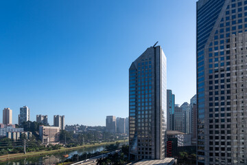 Fototapeta na wymiar Aerial view of the Marginal Pinheiros Avenue, Pinheiros River, corporate buildings and skyline of Sao Paulo city in sunny summer day. Brazil.
