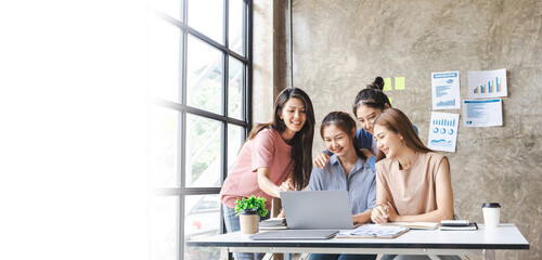 Four business women sharing ideas on work strategy by looking at data on laptop computer - Teamwork...