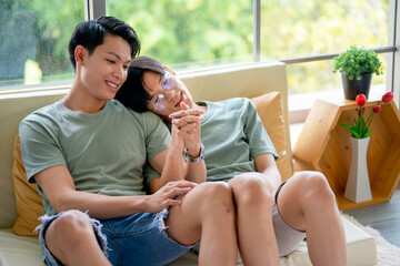 Obraz premium Two gay or lgbt man enjoy hug and tease each other with happy emotion sit on sofa near bed in bedroom with day light.