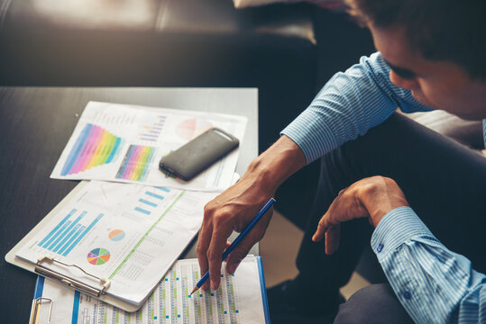 Business and Financial Planning Concept. Financial advisor' Hand  planning budget and work on annual report. Professional Businessman point and analysis summary report at home office.