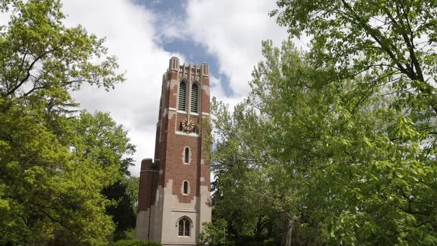 Beaumont Tower on the campus of Michigan State University in East Lansing, Michigan with gimbal video walking forward wide shot.