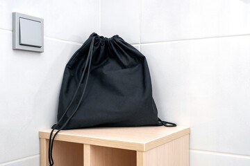 Black fabric bag on a shelf at a bathroom, bag for keeping accessories, hair dryer