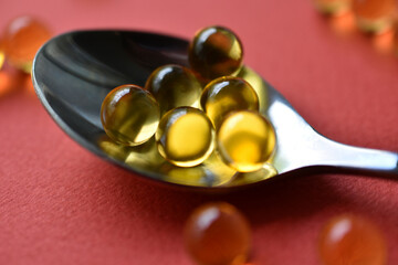 Yellow balls with fish oil on a red background. Glass yellow balls.