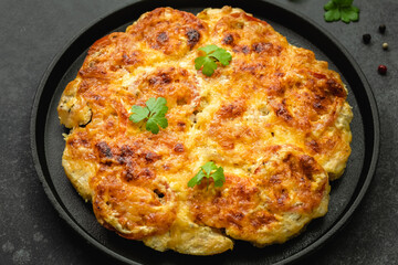 Baked cheddar ranch chicken, cheesy, vegetables in cast iron skillet. Top view, copy space, flat lay.