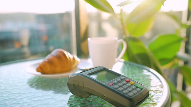 NFC credit card payment. Woman paying with contactless credit card with NFC technology to pay order on bank terminal in a cafe. Wireless money transaction. Wireless payment