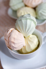 Delicious sweet multicolored air marshmallow lies on a serviced table in saucers