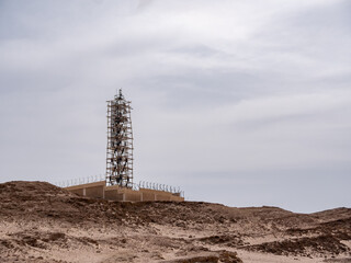 A radar tower under construction on a high desert hill.