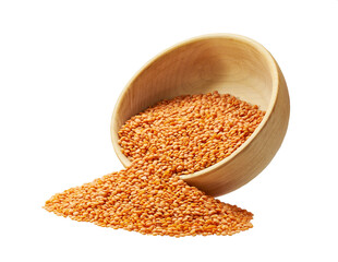Grains red lentils are scattered out of the wooden bowl.