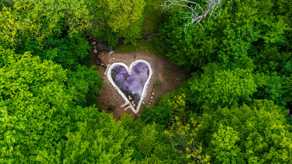 A woman resting by a pond hidden in the forest
