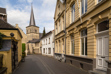 Old street with a view of the old small church in the touristic town of Valkenburg in Limburg.