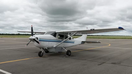 Fotobehang Eine Cessna 206 Stationair (Kleinflugzeug) auf dem Vordeld eines Flugplatz (Airstrip) in Simbabwe © Lars