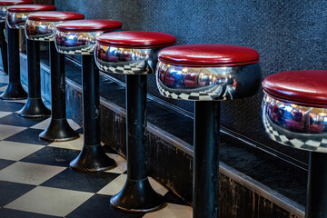 A classic metal stool with red vinyl padding can be found at this small diner in upstate NY. Row of...