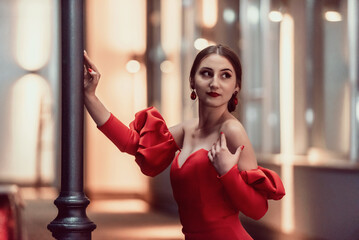 a glamorous woman in a red dress posing in the city