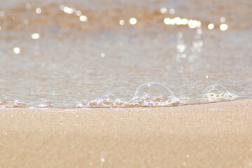 Against the background of sea sand bubbles from the sea wave.