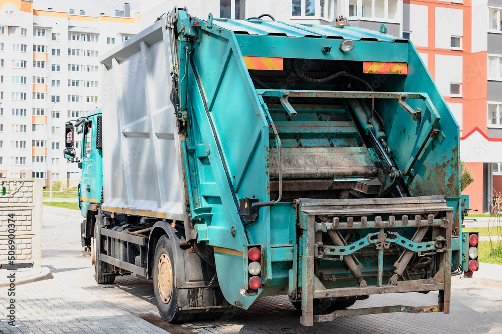 Aufkleber A garbage truck picks up garbage in a residential area. Loading mussar in containers into the car. Separate collection and disposal of garbage. Garbage collection vehicle.