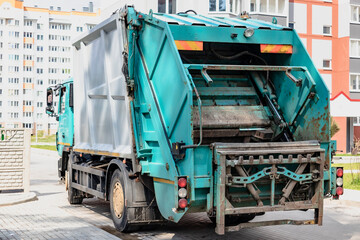 A garbage truck picks up garbage in a residential area. Loading mussar in containers into the car. Separate collection and disposal of garbage. Garbage collection vehicle.