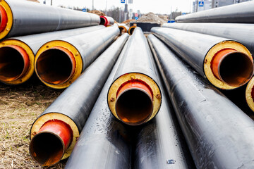 Insulated pipe. Large metal pipes with a plastic sheath at a construction site. Modern pipeline for...