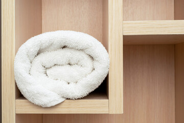 Obraz na płótnie Canvas Stacked roll white soft towel for shower, bathroom interior