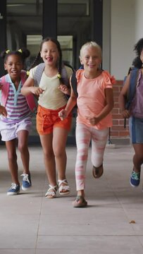 Video of happy diverse pupils running on school corridor