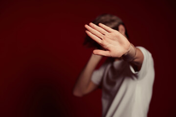 young man in white t-shirt showing stop gesture at camera