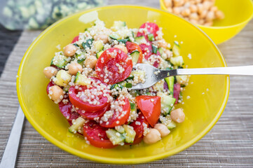 Vegan quinoa salad meal with fresh vegetables.