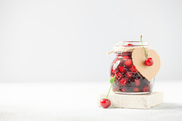 Obraz na płótnie Canvas Homemade cherry jam in a jar and fresh berries on the table. Copy space