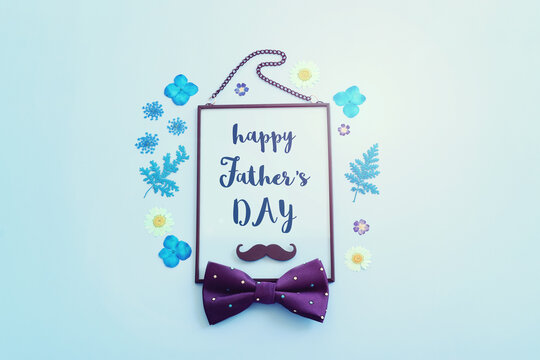 Father's day concept. bow tie, funny moustache and frame over blue background. top view, flat lay