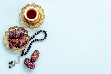 Islamic rosary with dates and tea. Ramadan Kareem concept.