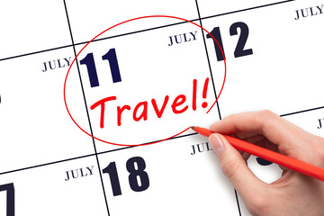 11th day ofJuly. Hand drawing a red circle and writing the text TRAVEL on the calendar date 11July. Travel planning. Summer month. Day of the year concept.