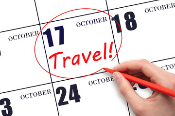 17th day of October. Hand drawing a red circle and writing the text TRAVEL on the calendar date 17...