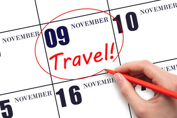 9th day of November. Hand drawing a red circle and writing the text TRAVEL on the calendar date 9 November. Travel planning. Autumn month. Day of the year concept.