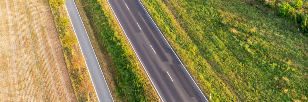 Panoramic Image. Empty Asphalt Road And Bike Lane Between Fields From Above