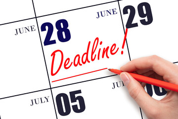 28th day of June. Hand drawing red line and writing the text Deadline on calendar date June 28....