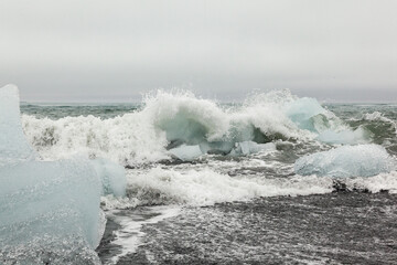 Waves breaking in icebergs. beach in jokulsarlon.