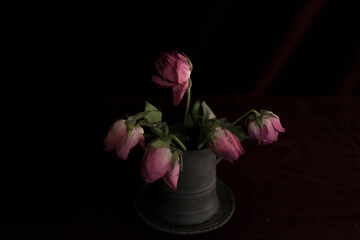 Fototapeta na wymiar Pink Dried Rose Buds in A Pewter Tankard