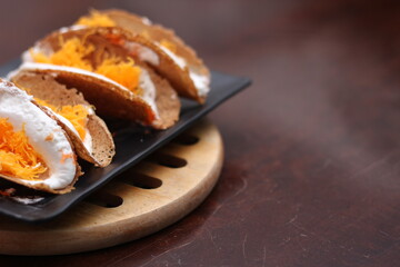 Thai Food, Thai Crispy Pancakes served in a black plate on a brown wooden table.