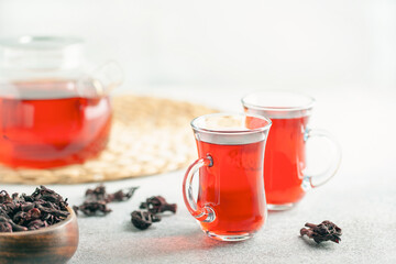 Red tea carcade in glasses and dried hibiscus flowers.