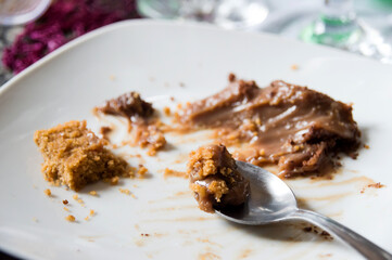 Dessert spoon with dulce de leche and pastry crumbs