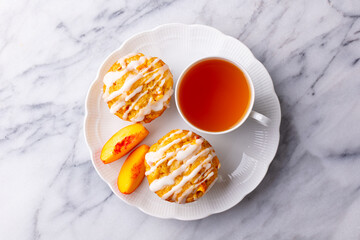 Peach cupcakes, muffins with cup of tea. Marble background. Close up. Top view.