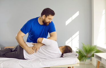 Professional chiropractor, physiotherapist, osteopath, or manual therapist working with man and...